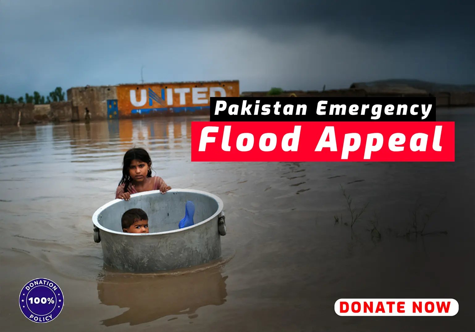 Children in a metal tub in floodwater with Pakistan Flood Appeal banner.